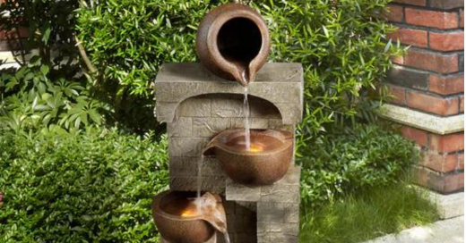 A cascading outdoor water fountain on a faux brick plinth