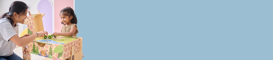 A young boy sits at a table sized just for him