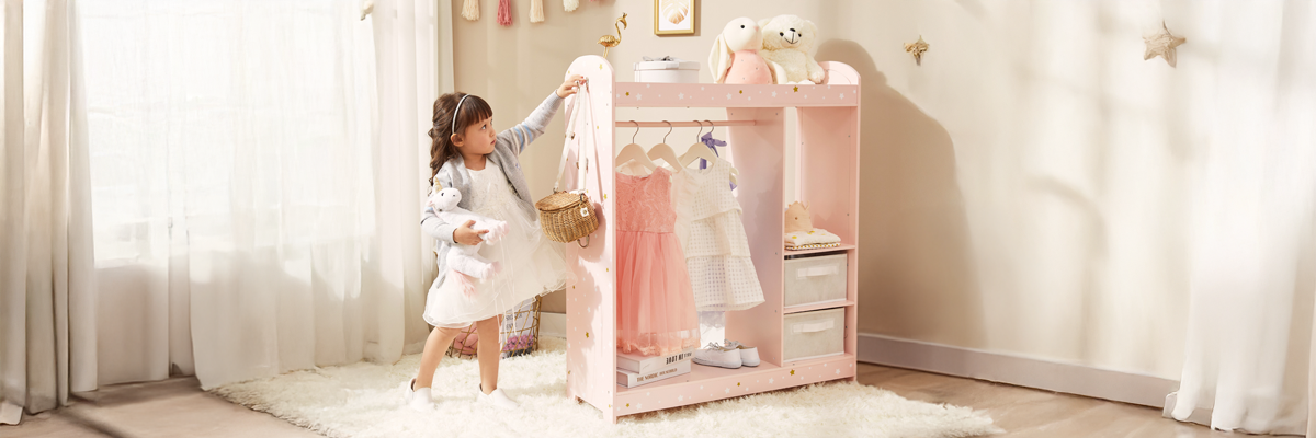 A young girl hangs her purse on the child sized clothing rack