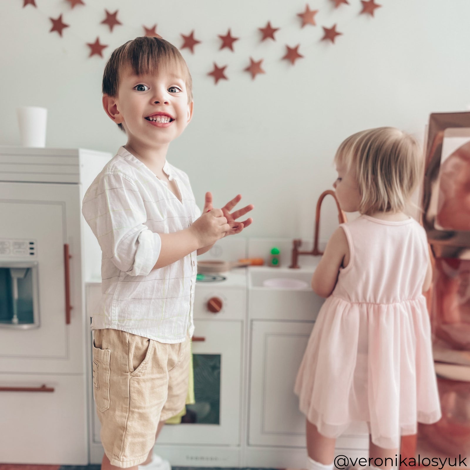 a boy and girl playing with a white teamson kids little chef Paris kitchen