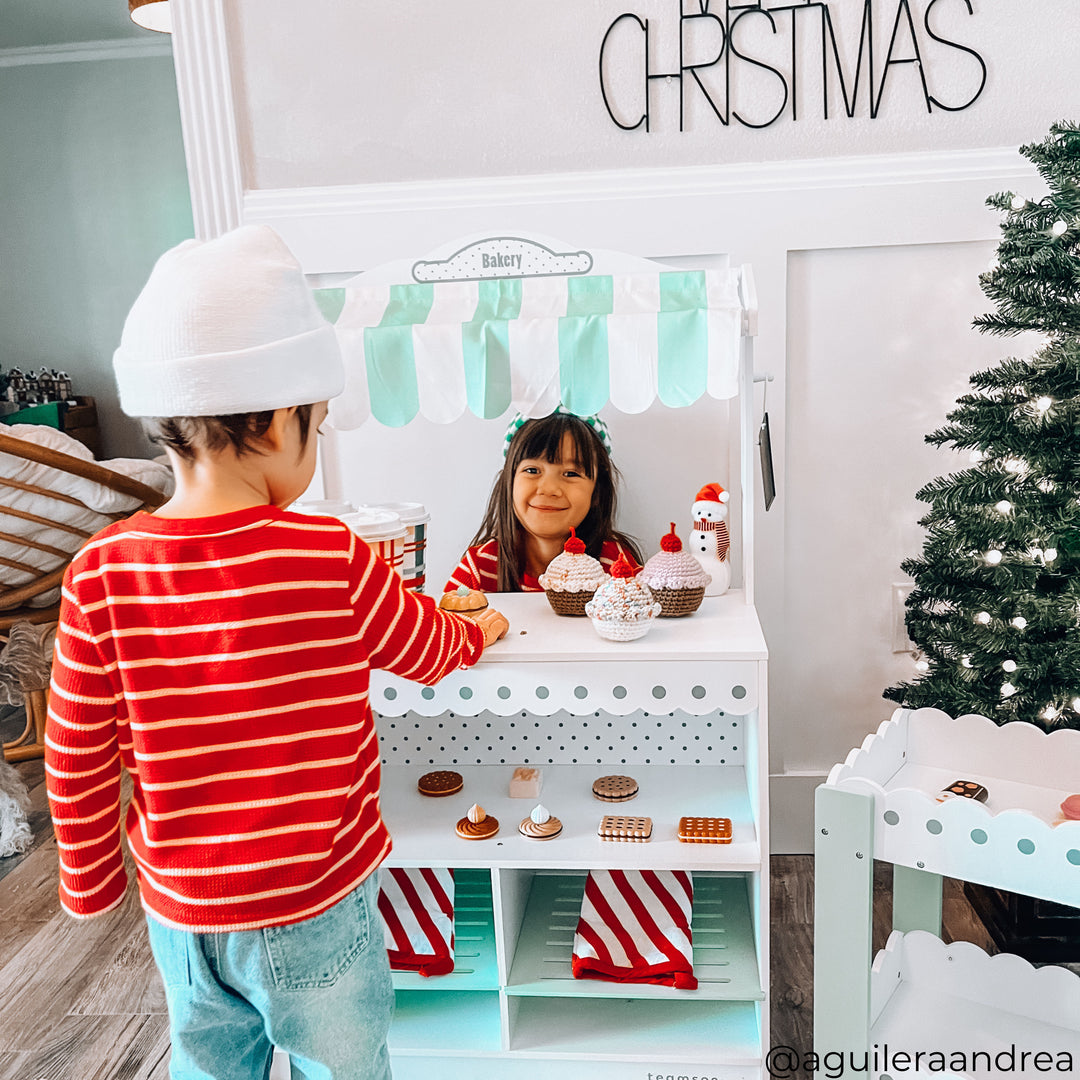 A girl and a boy playing with a play market stand