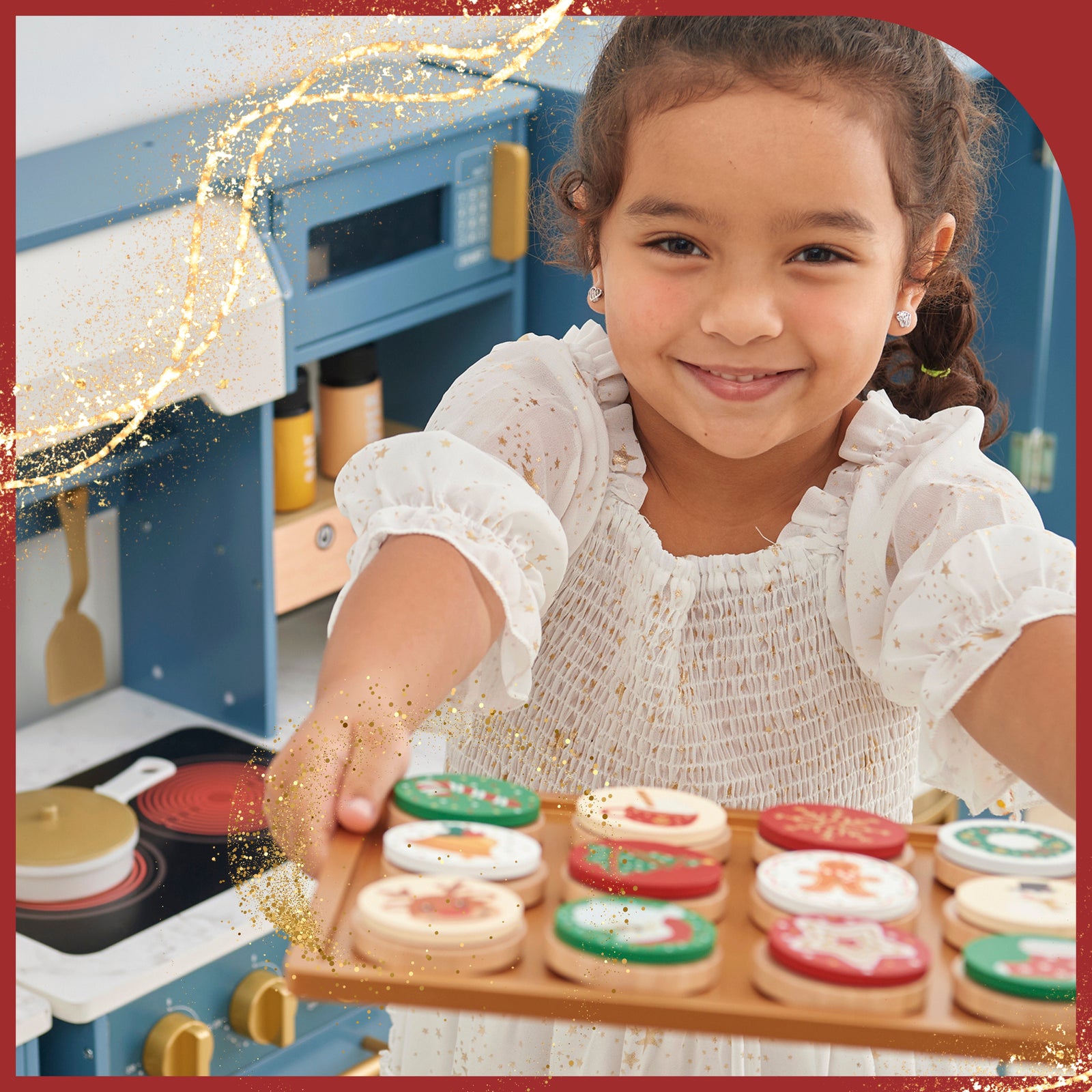 a young girl proudly holds a tray of "just baked" christmas cookies