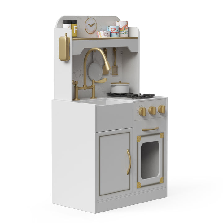 A side view of a white and gold play kitchen