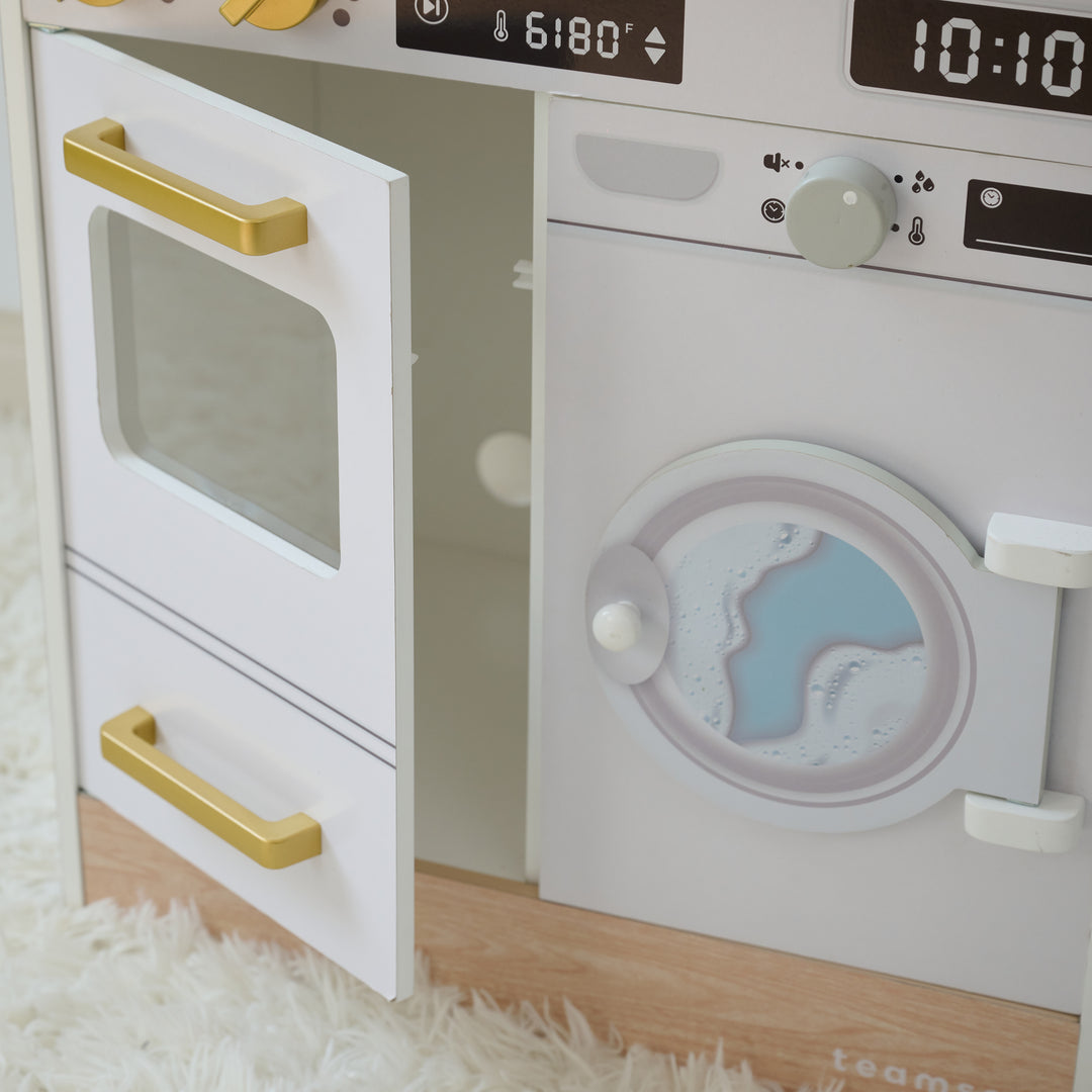 Close-up of play kitchen with oven door open and washer featuring a printed water design, set on a soft white rug.