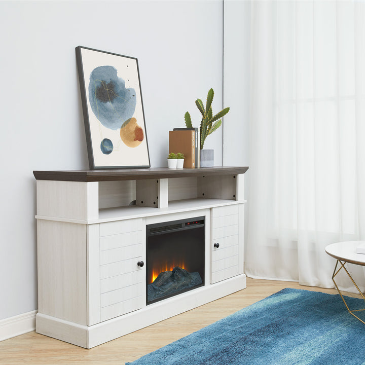 A white entertaiment center with an electric fireplace next to a blue rug
