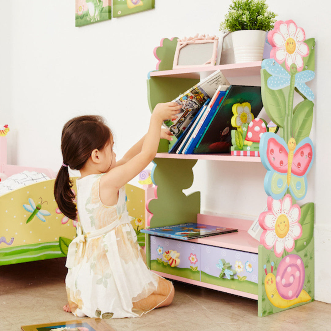 A little girl putting books on a the middle shelf of a garden-themed bookshelf