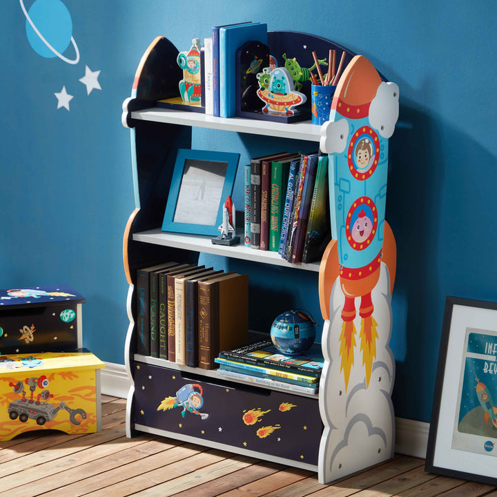 The Outer Space Bookshelf with Drawer with books and toys on the shelves against a blue wall.