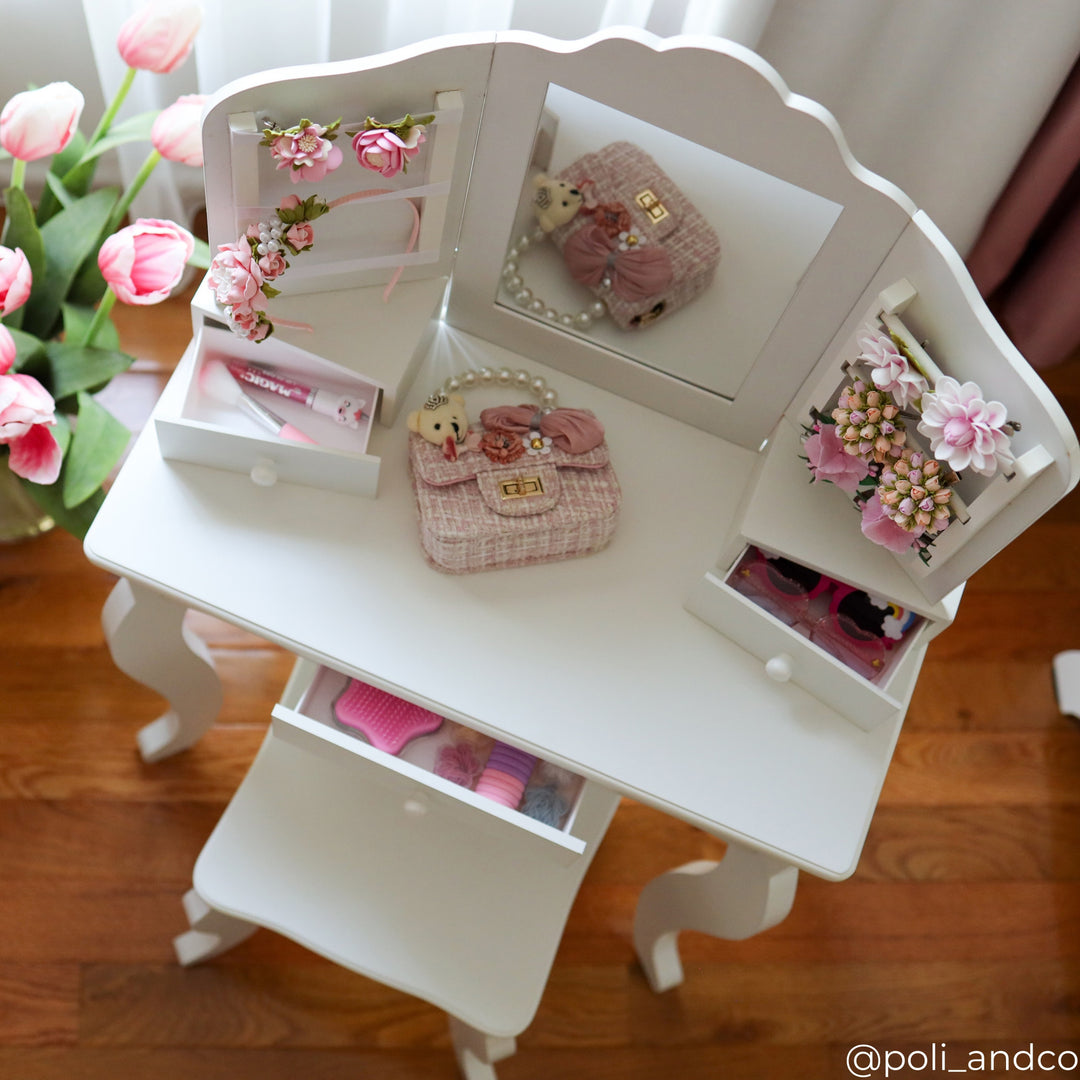 A view of a white vanity table with items in the drawers and flowers