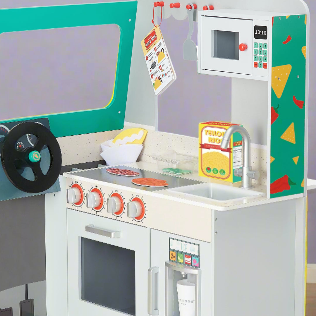 A colorful toy kitchen and toy food truck setup featuring a play stove with knobs, a sink, microwave, and a steering wheel.