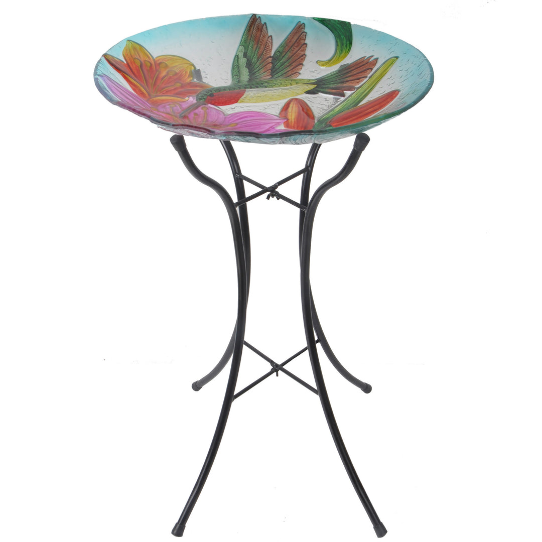 the birdbath featuring lilies and hummingbird stand on a tall black iron stand
