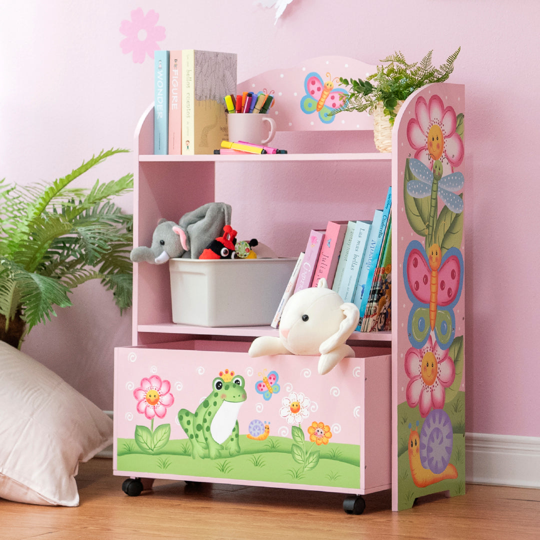 A pink bookcase with a stuffed animal and a Fantasy Fields Magic Garden Kids Wooden Toy Organizer with Rolling Storage Box, Pink.