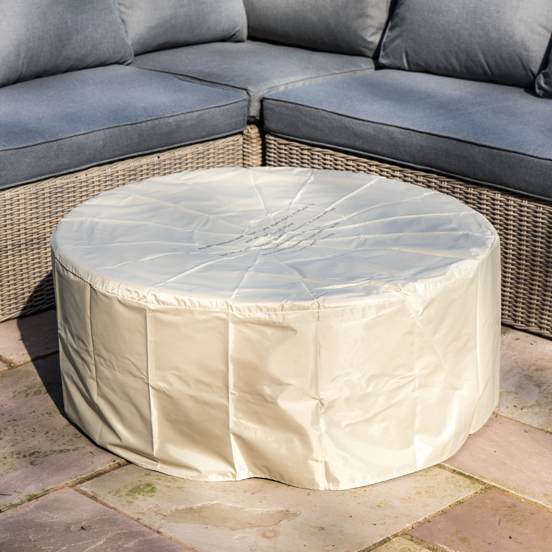 A weather-resistant cover over a round gas fire pit