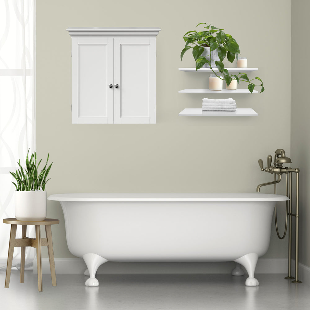 A white two-door wall cabinet hung above a bathtub in a sage bathroom