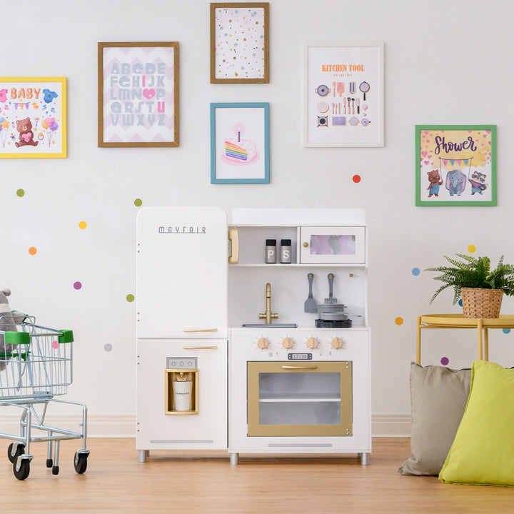 A white and gold retro-styled play kitchen for kids in a playroom