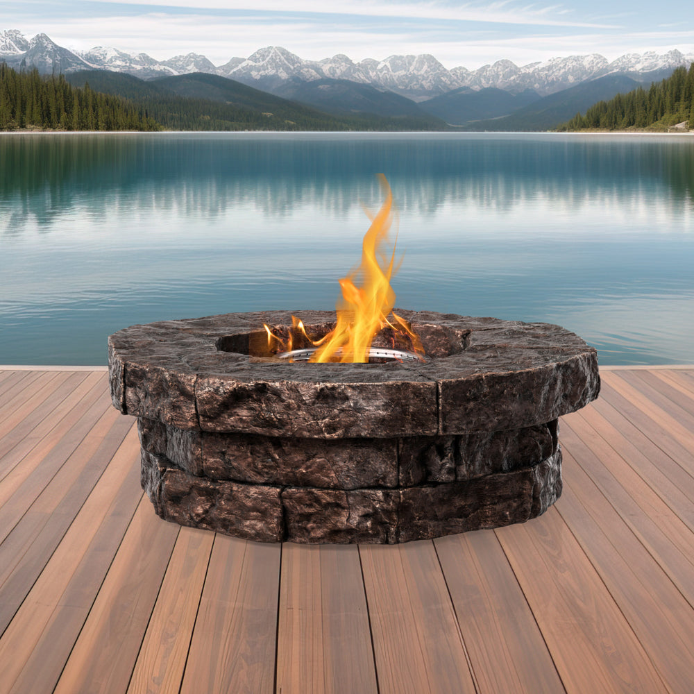 A round faux brick gas fire pit with a majestic lake in the background