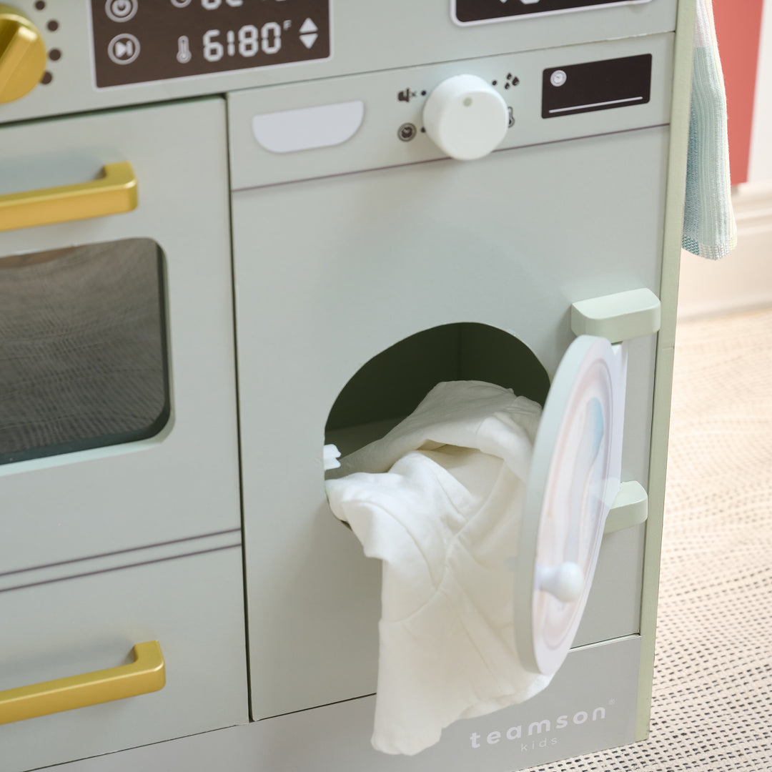 Close-up of play washer section with door open and toy laundry inside, part of a kitchen-laundry combo playset.