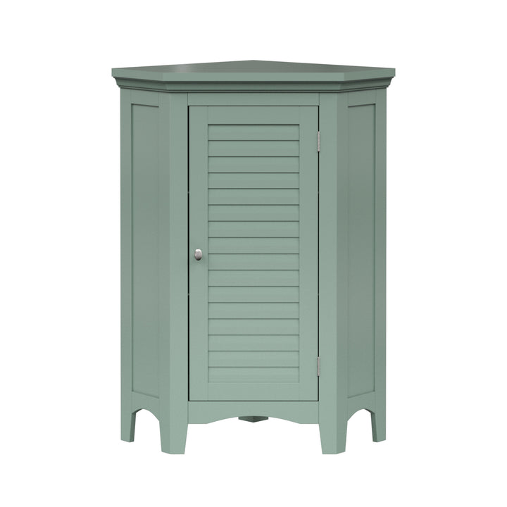 A sage green corner floor cabinet with silver knobs and two faux louvered doors.