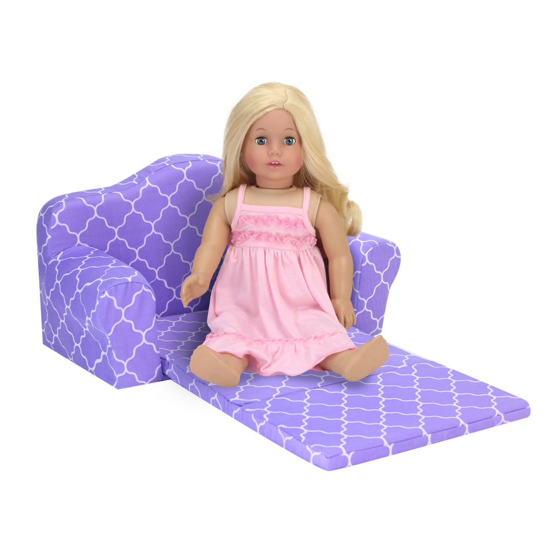 A blonde 18" doll in pink nightgown sitting on a purple pullout couch