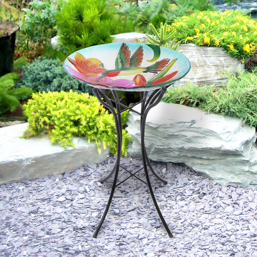 Hummingbird glass bowl birdbath in a garden