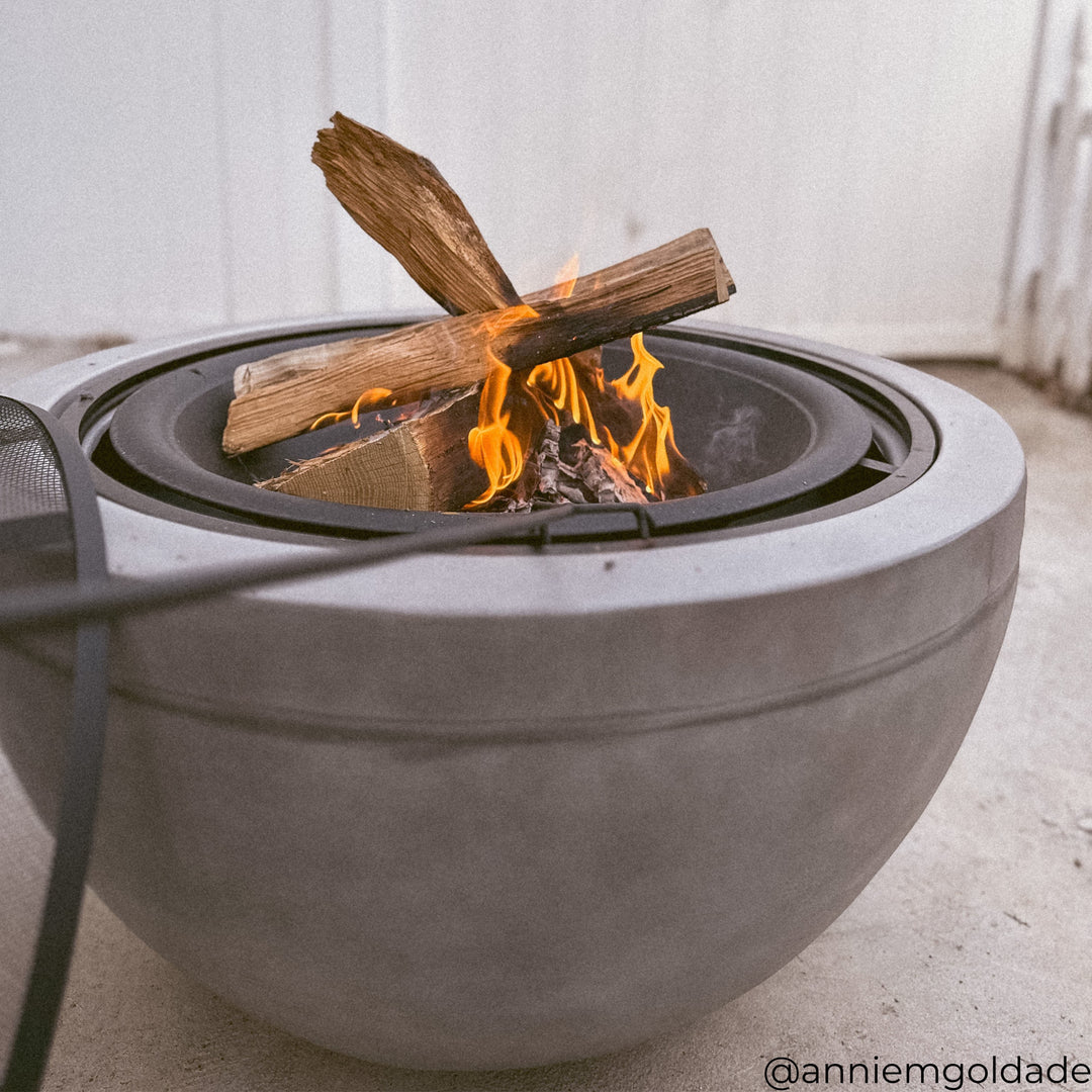 A round gray wood-burning fire pit