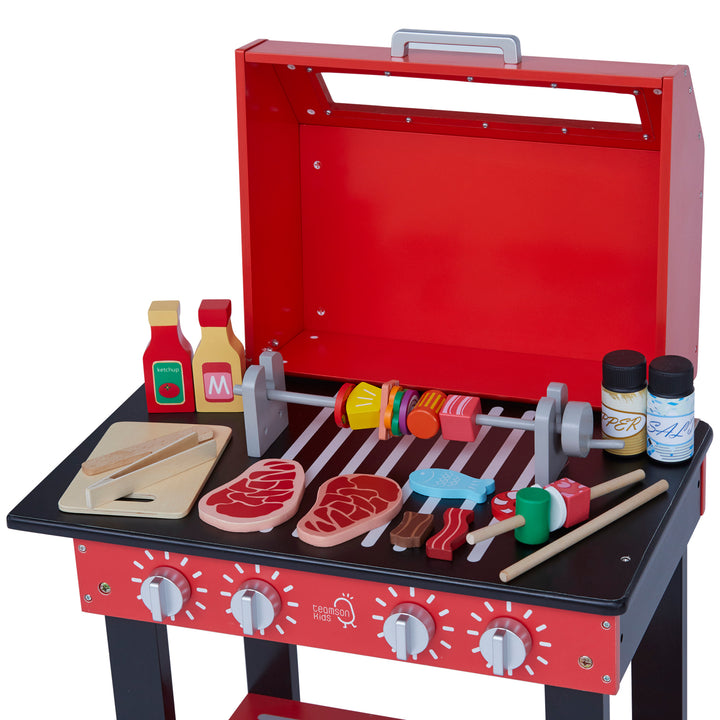 A play BBQ grill with pretend food and condiments