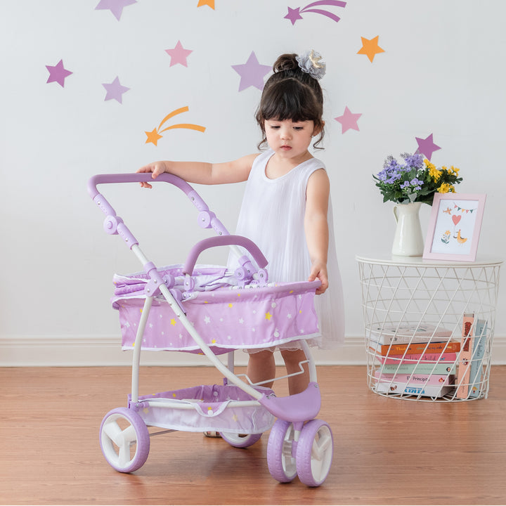 Young child playing with her purple star print stroller