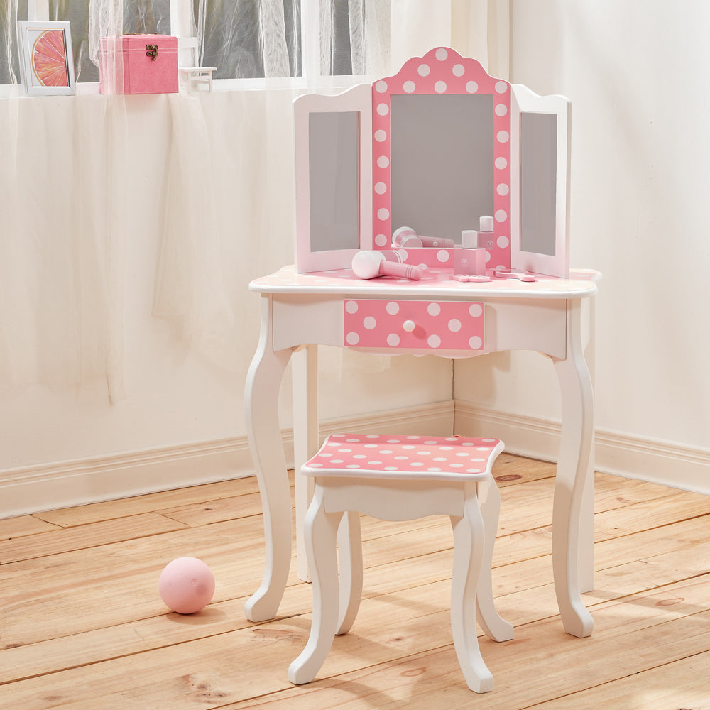 A kids' vanity table and matching stool with trifold mirror, white with pink and white polka dot accents INin a white bedroom with light oak flooring